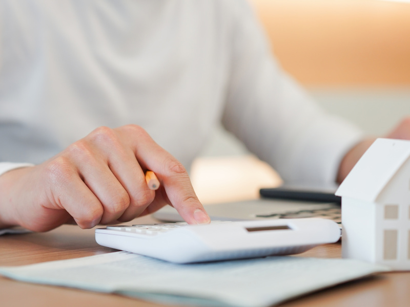 Frau rechnet am Taschenrechner Bewirtschaftungskosten aus